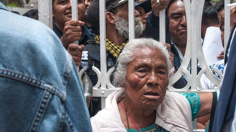 Una señora, que desde afuera pedía le regresaran su casa, pregunta "¿qué harán con los adultos mayores que se están muriendo de hambre?". Logra ingresar pero no le es permitido el paso más allá de la reja. Foto: Angélica Escobar/Forbes México.