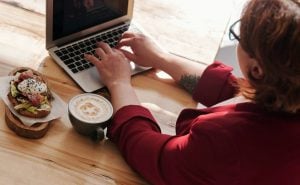 mujer comiendo sandwich home office