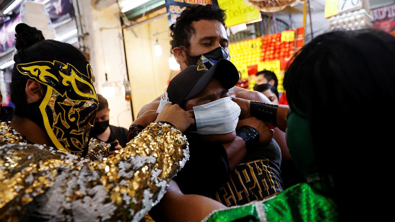 Mascarillas a la fuerza: luchadores reparten cubrebocas en el metro