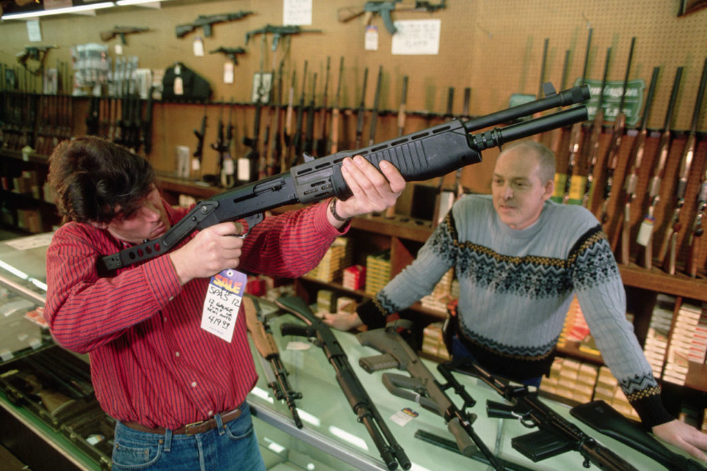 Venta de arms Man Examining a Rifle at a Gun Shop