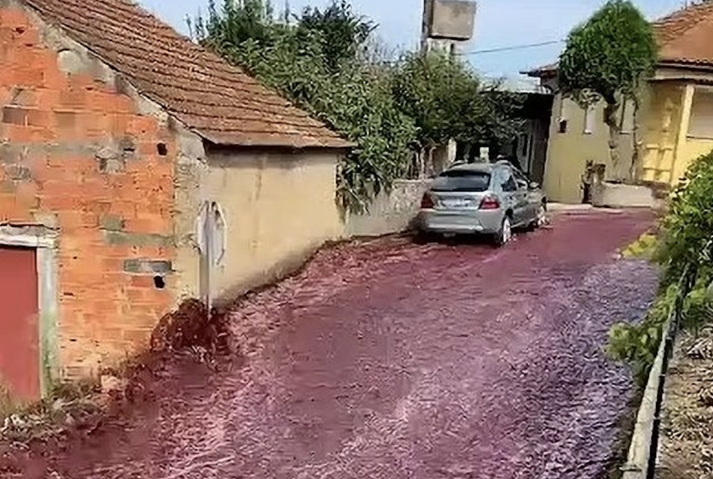 um rio de vinho tinto inunda as ruas de uma cidade em Portugal