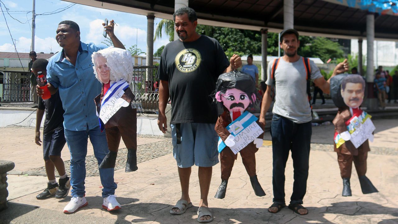 Migrantes queman piñatas de presidentes en protesta contra la cumbre migratoria