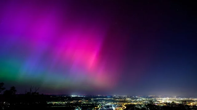 La aurora boreal o aurora boreal ilumina el cielo nocturno de Viena durante una tormenta geomagnética. APA/AFP VÍA GETTY IMAGES