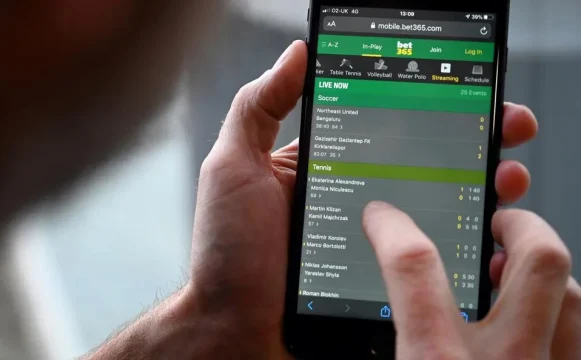 Un hombre posa para una foto con la web de apuestas online Bet365. AFP vía Getty Images